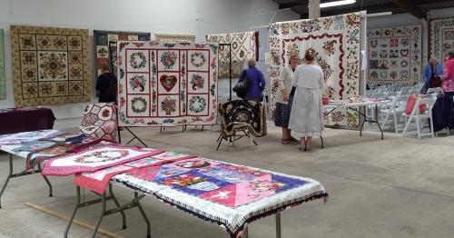 People in hall looking at exhibition of quilts