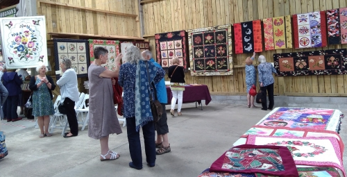 People in hall looking at exhibition of quilts
