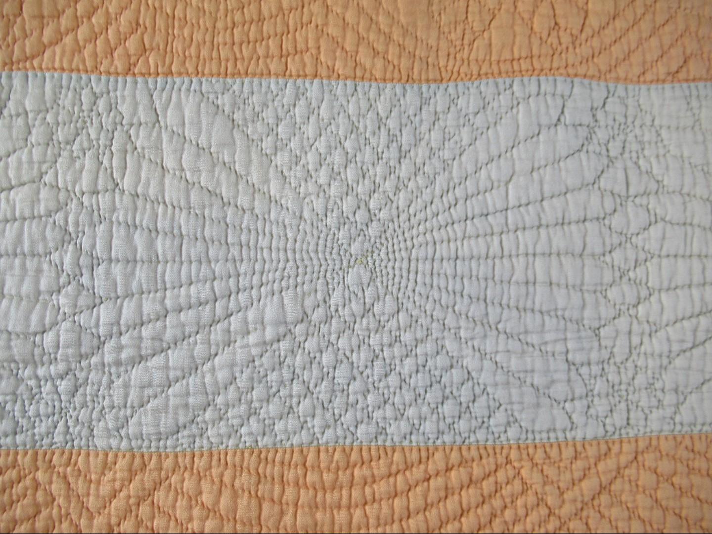 Fan quilting detail on cream strip