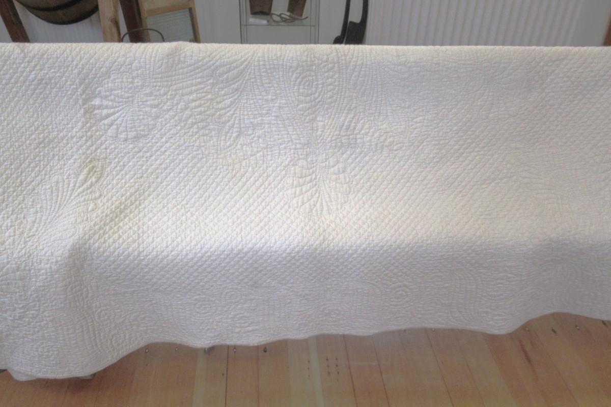 White wholecloth quilt showing half
