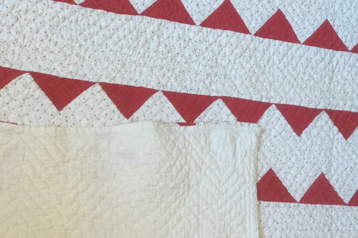 Red and print zig zag quilt with white corner turned