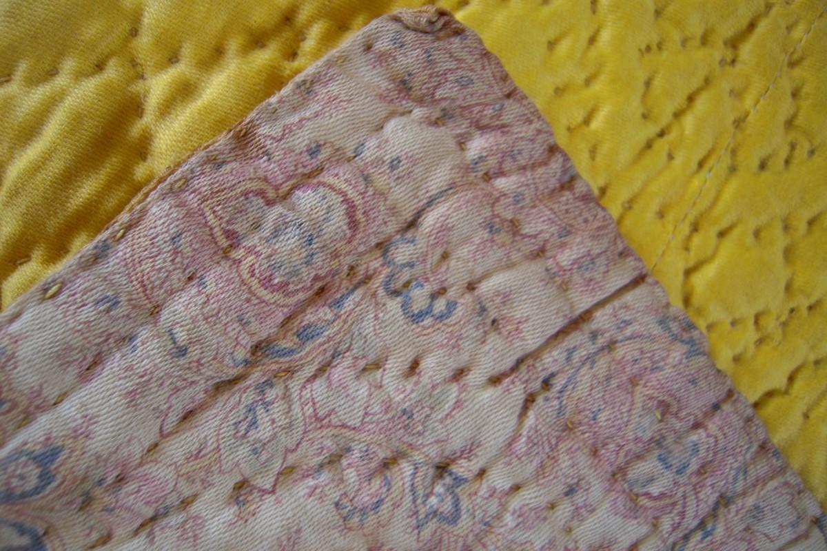 Close up showing reverse paisley print and the hand stitched edge
