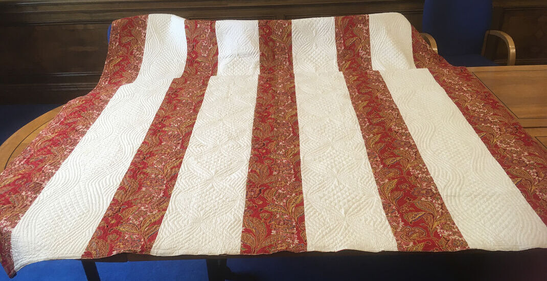 Quilt made from alternating strips of red and white fabric
