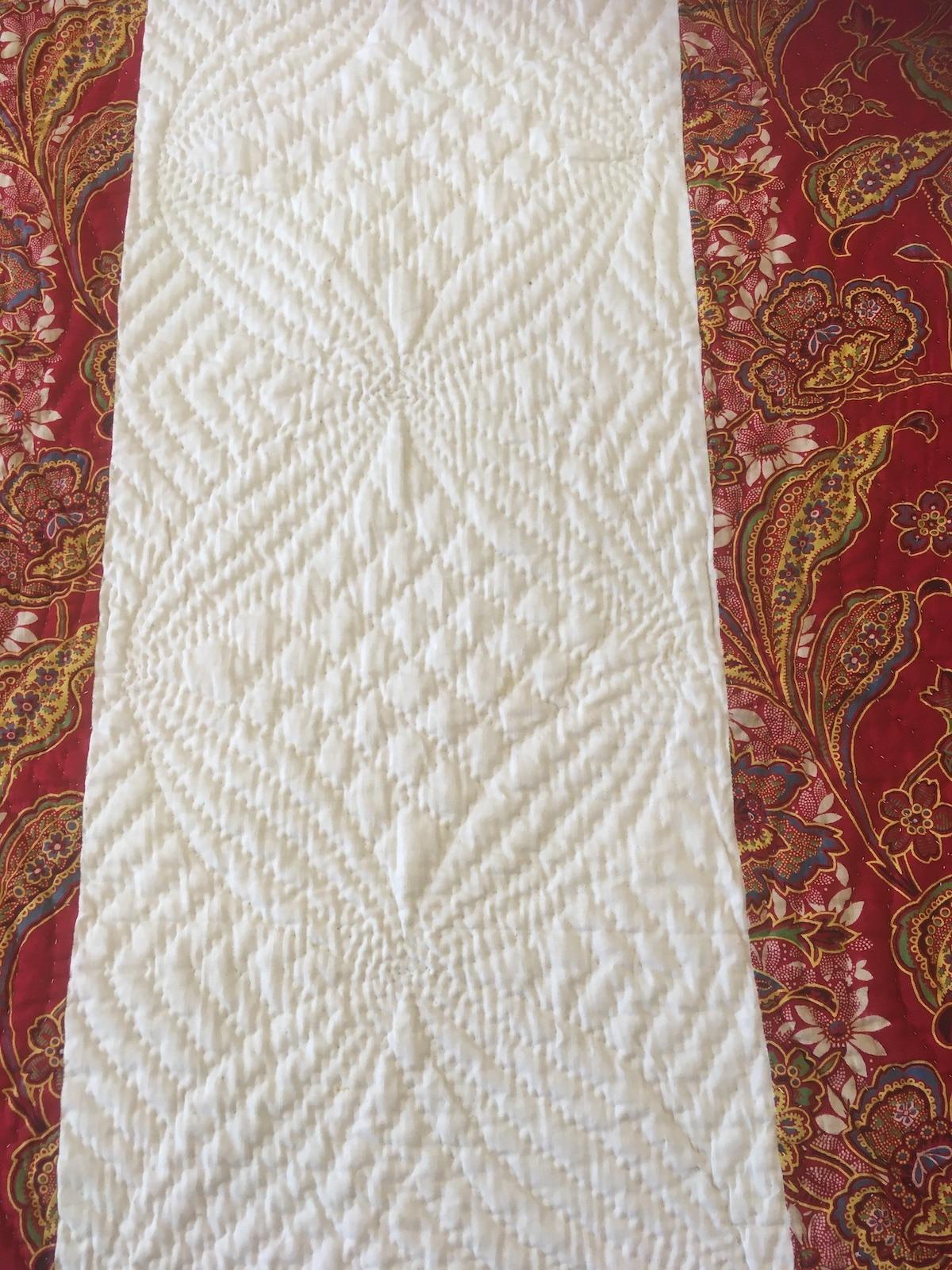 Hand quilting design of large four petalled flowers
