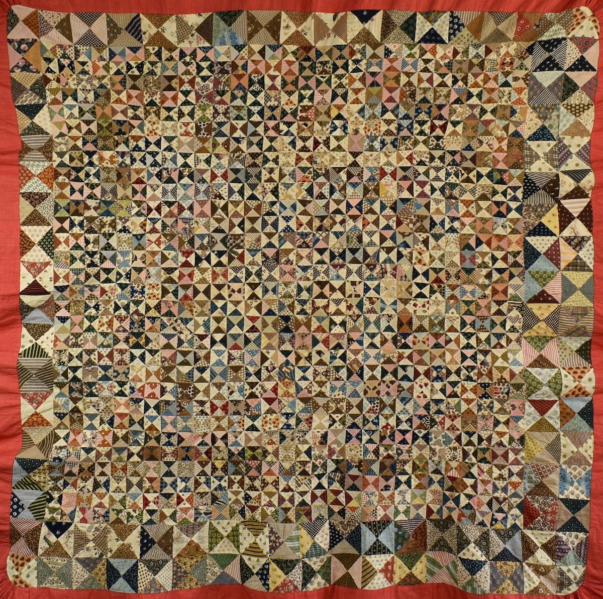 Many small triangles of printed fabric assembled into patchwork