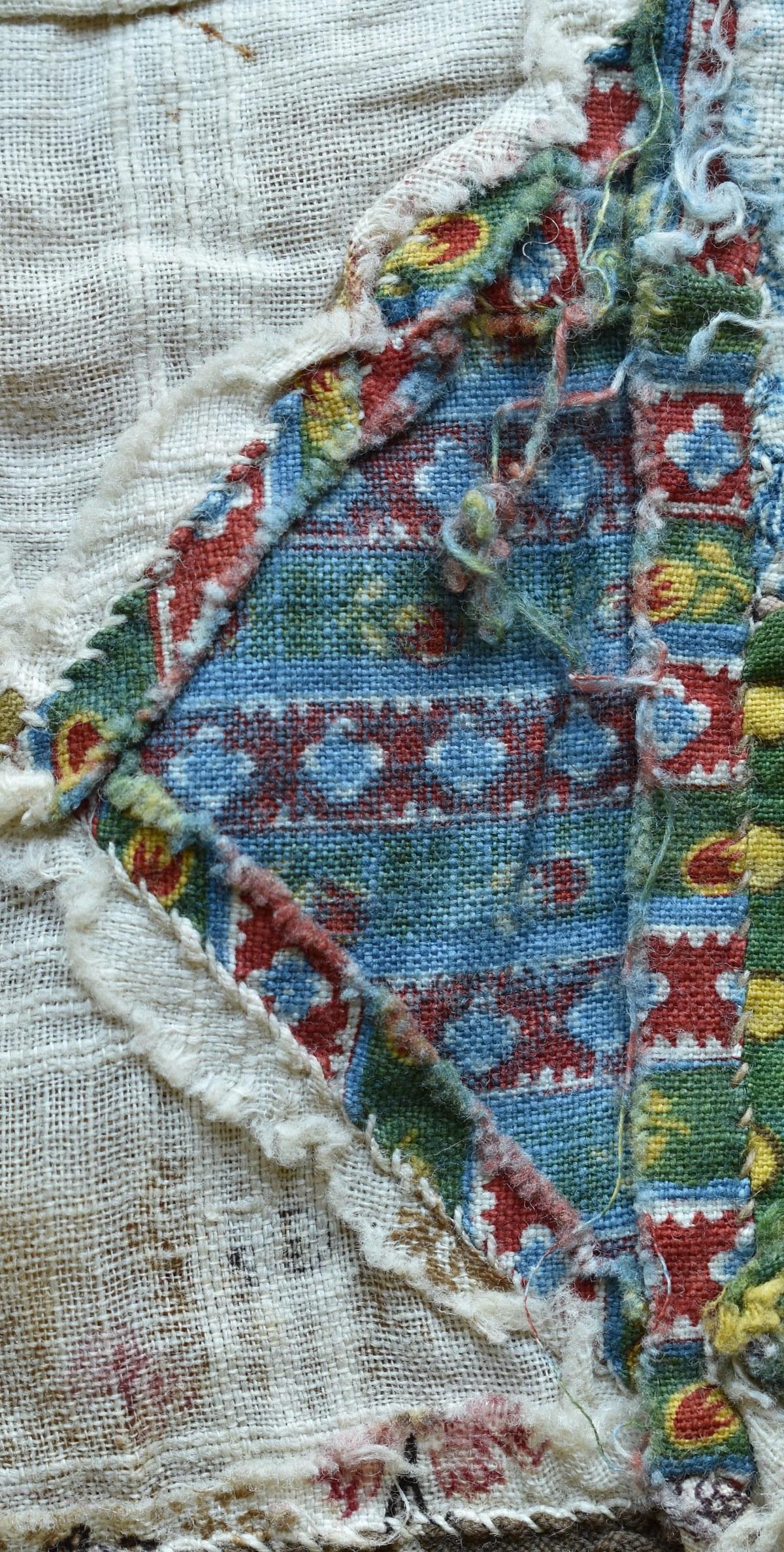 Back of yellow, red and green printed fabric showing an all-over blue tone