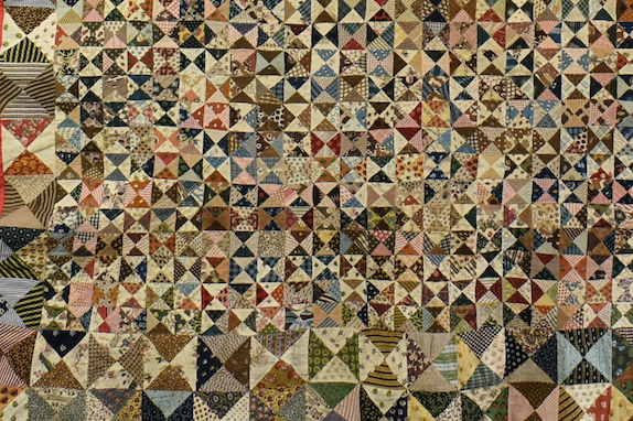 Many small triangles of printed fabric assembled into patchwork