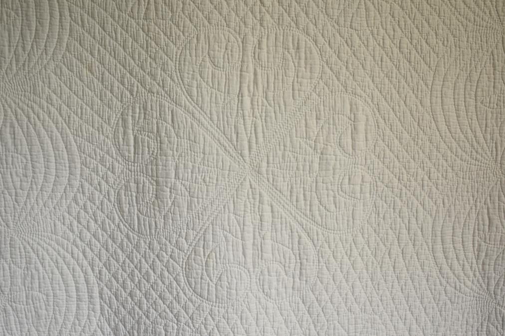 White quilt with design of four hearts