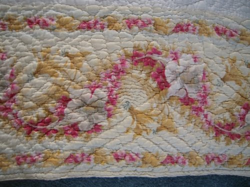 Close up image showing pink and yellow floral border pattern on quilt.
