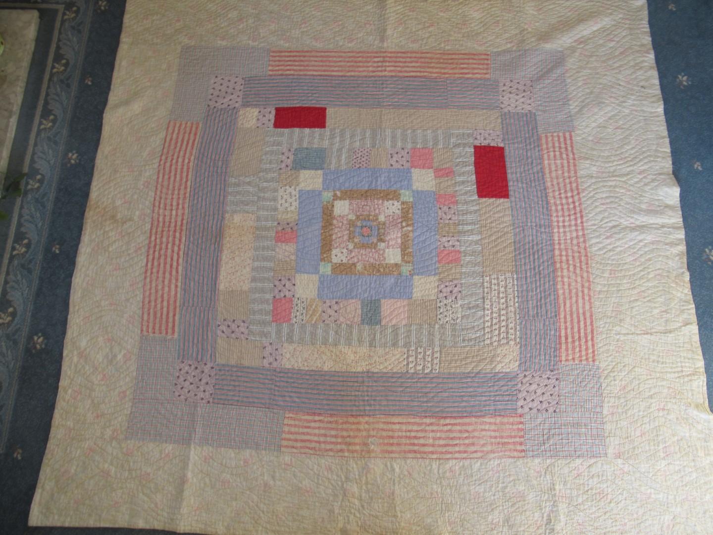 A patchwork frame quilt in pale blues, pinks and beiges.
