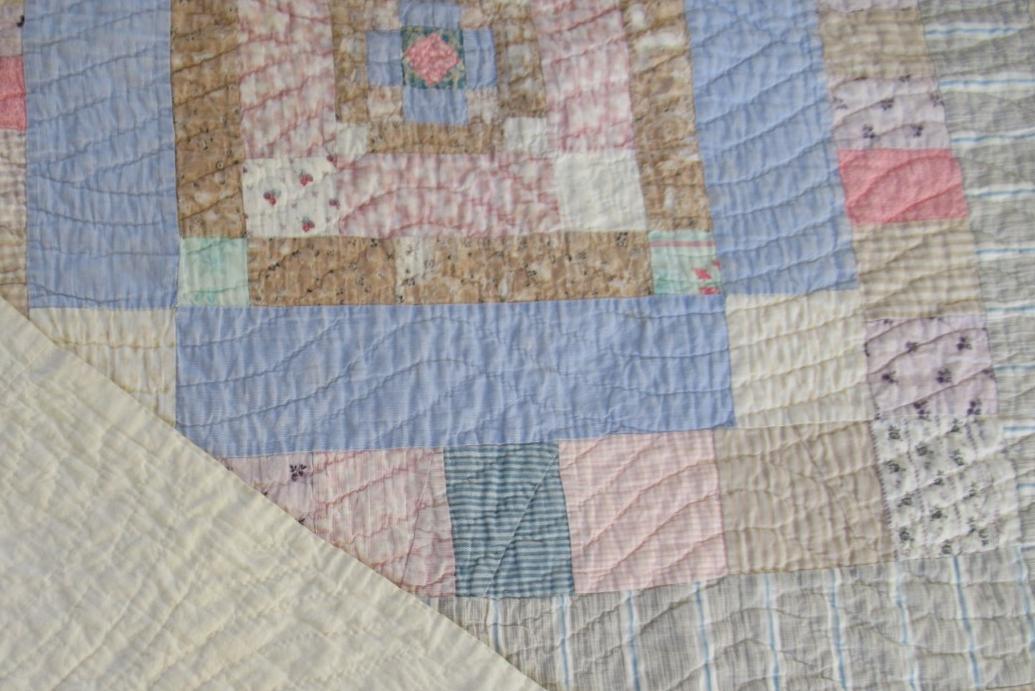 Patchwork quilt of many pieces in pale blues and beiges