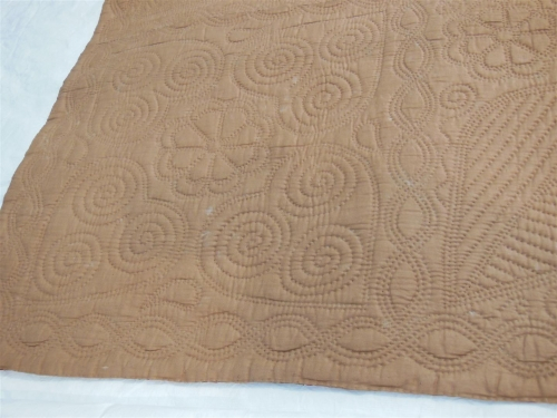 Beige wholecloth quilt with quilted motifs
