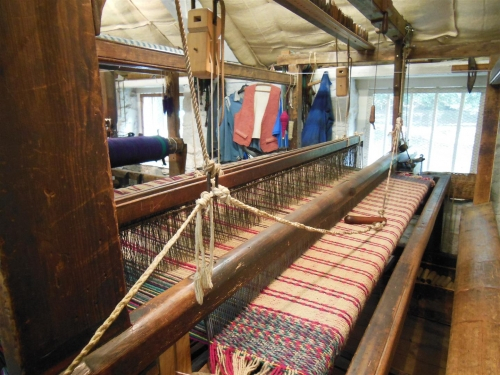 Weaving loom with red and cream cloth