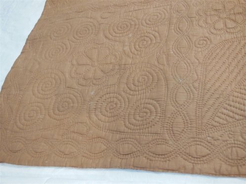 Beige wholecloth quilt with quilted motifs