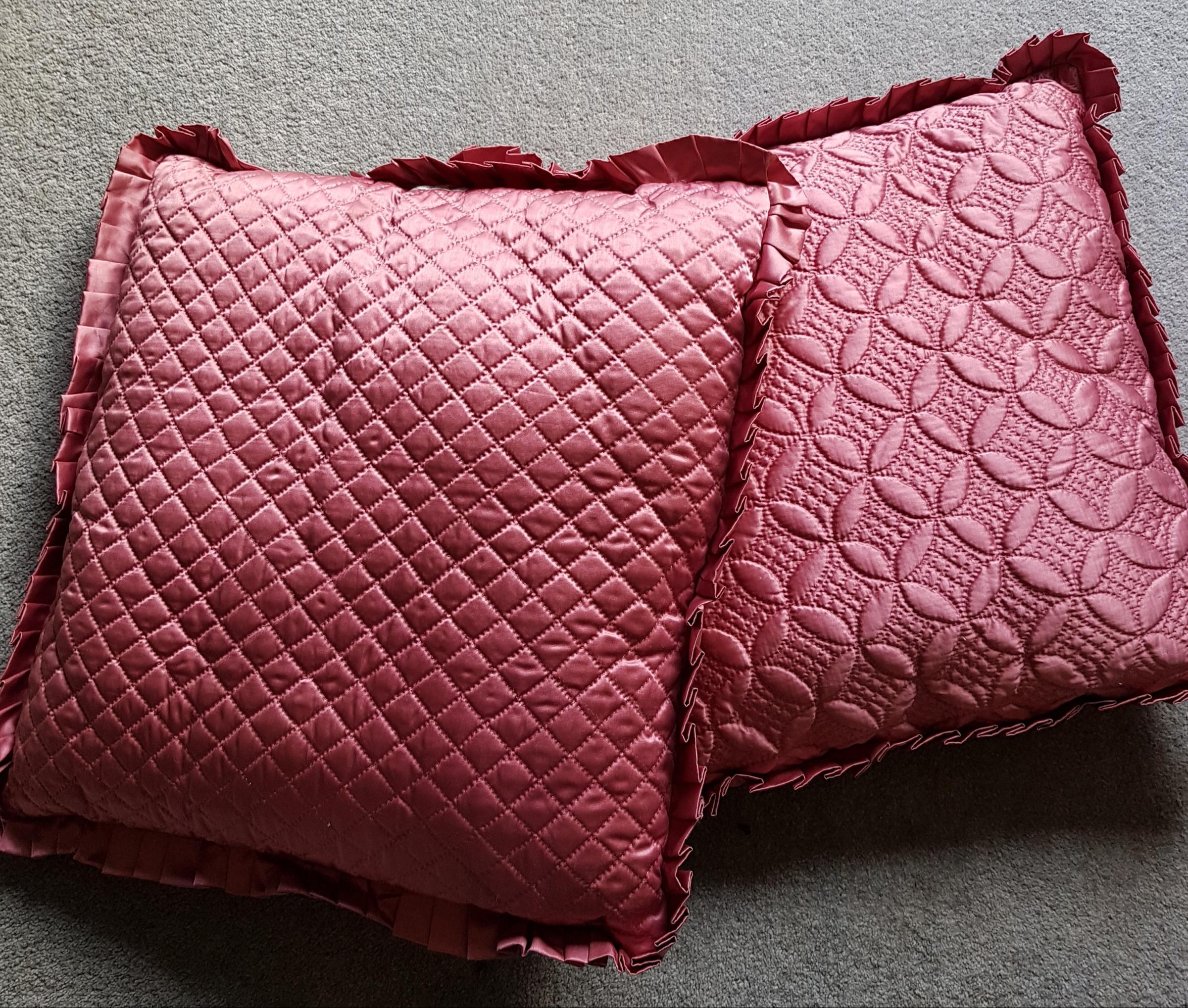 Reverse of two pink satin cushions