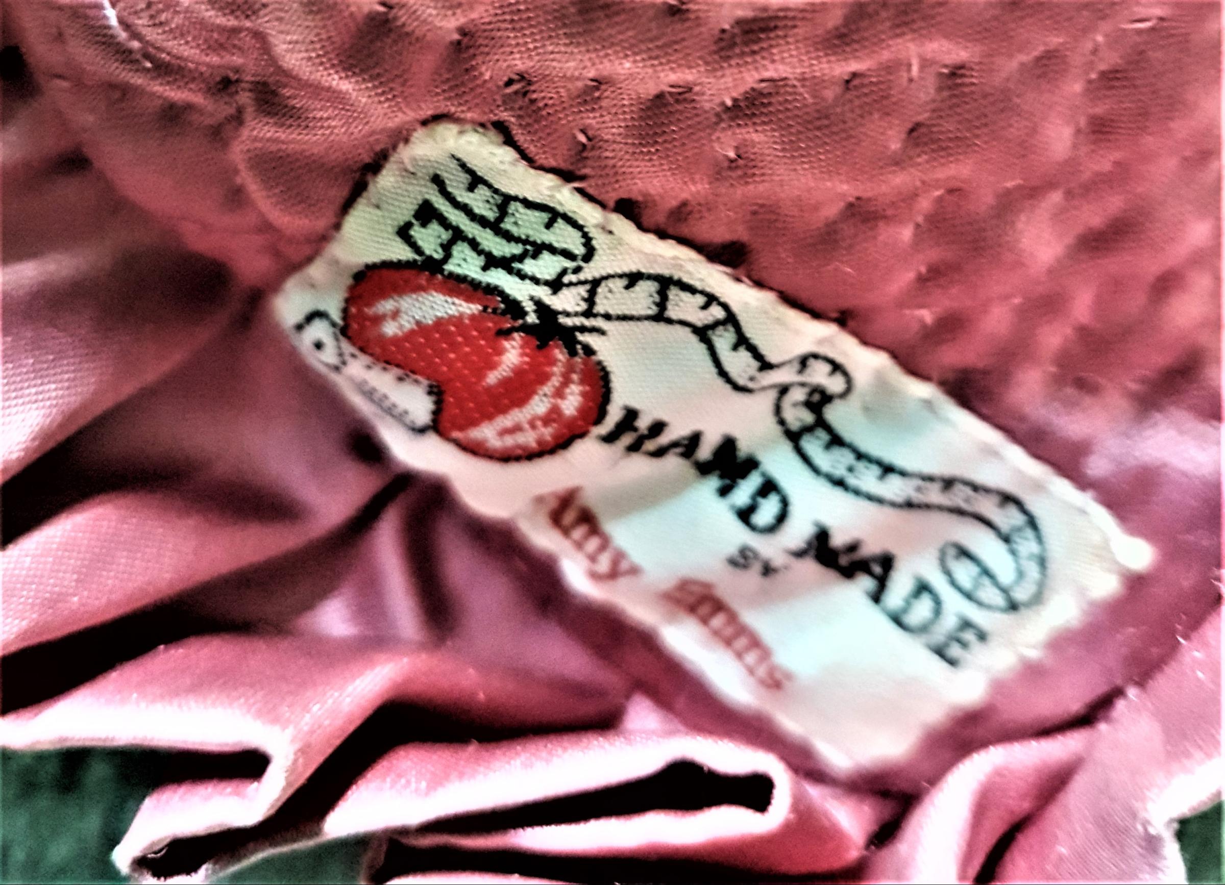 Stitched white label on pink satin