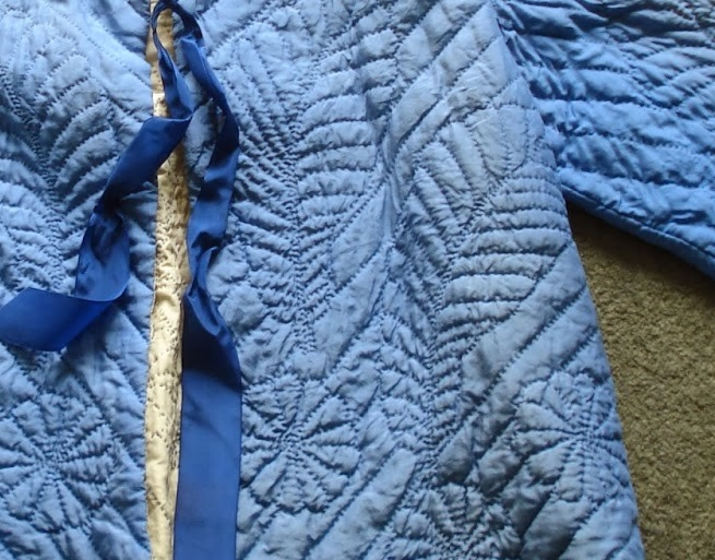 Close up of feather and flowers design on front of bed jacket