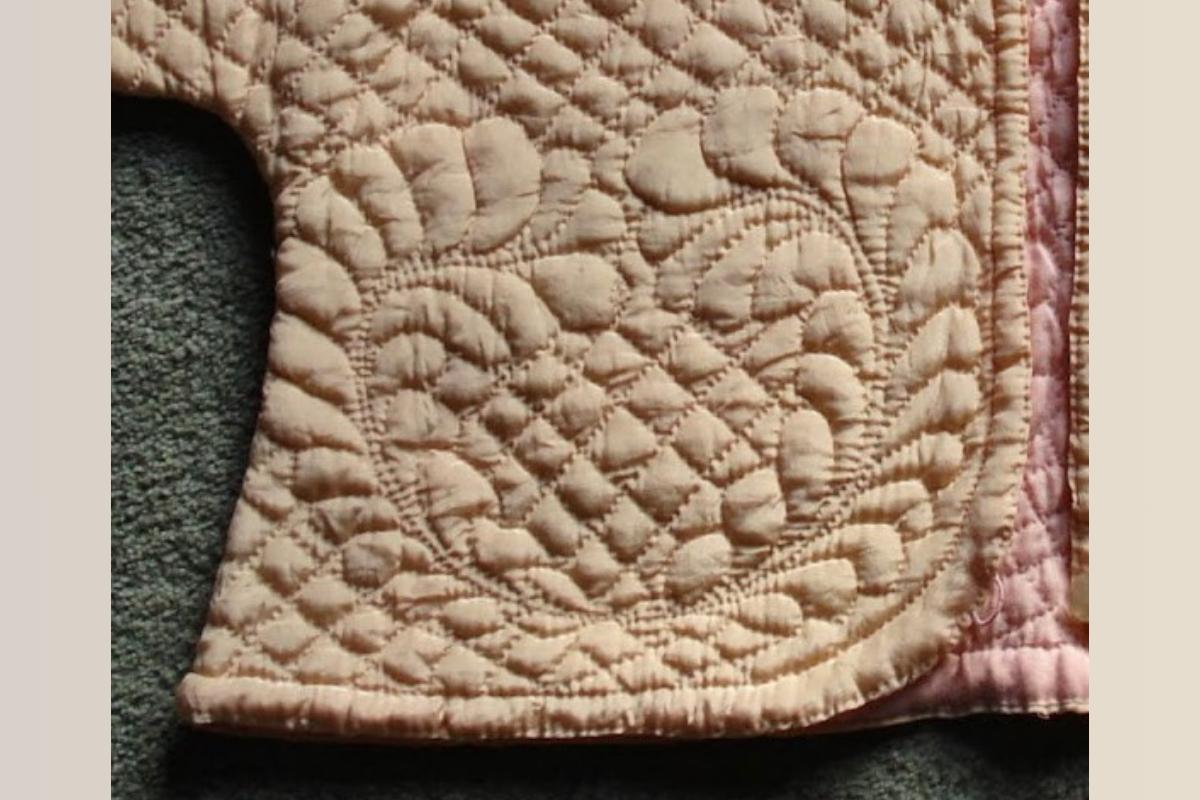 Close up of feathered wreath design on front of bed jacket