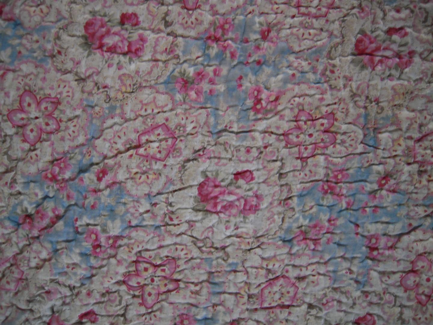 Fabric with pink floral motifs on a blue background