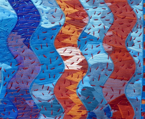 Blue and orange curved zig zags with large stitch quilting