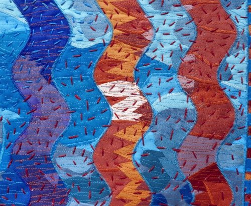 Blue and orange curved zig zags with large stitch quilting
