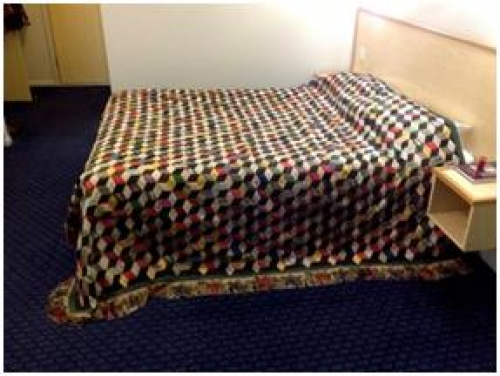 Multi coloued quilt on bed