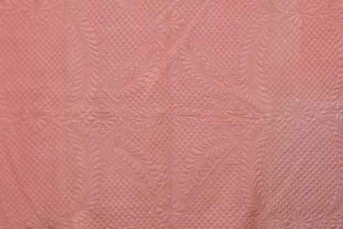 Pink quilt with patterned stitching