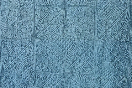 Blue quilt with patterned stitching