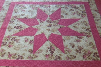 Pink and floral quilt in a star pattern