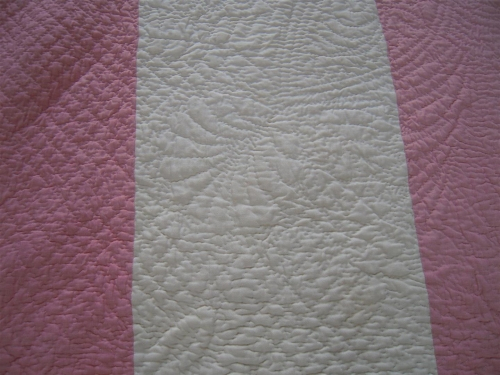 Detail of quilting on pink and white strippy