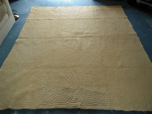 Pale yellow quilt on floor
