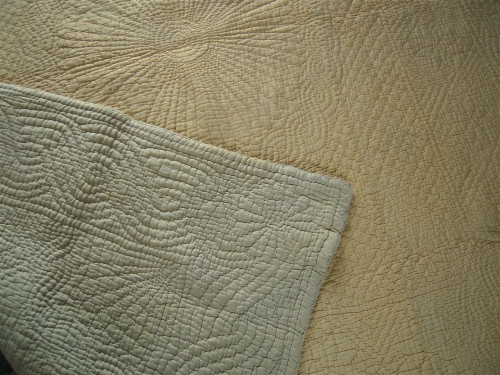 Pale green corner folded over pale yelow quilt