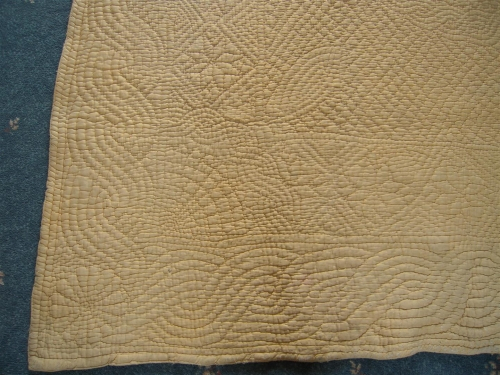 Corner of yellow quilt with stitched detail