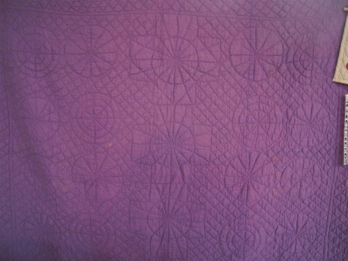 Mauve quilt with stitched patterns