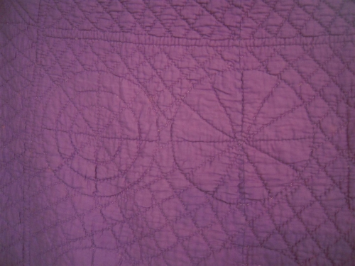 Mauve quilt with stitched motifs