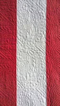 Red and white strippy quilt detail