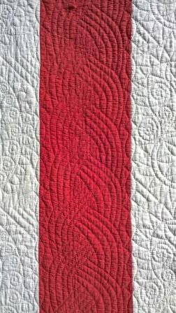 red and white quilt detail with cable design