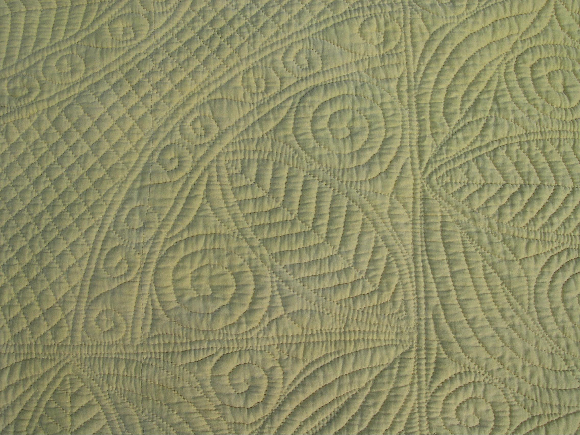 Fan detail on pale yellow quilt