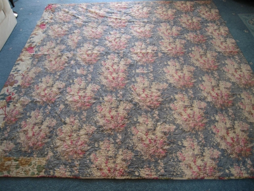 Blue and pink floral quilt laying on floor