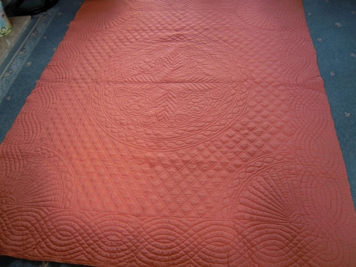 Peach quilt with stitched patterns