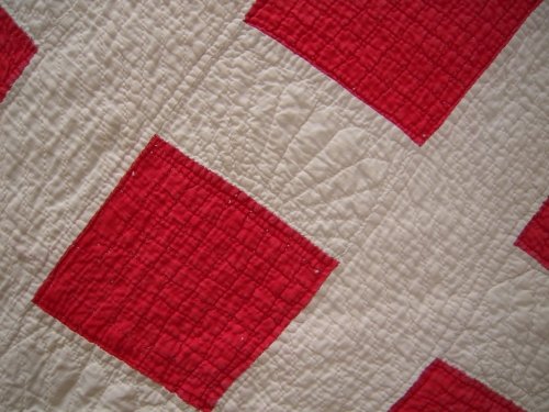 Red squares on white quilt