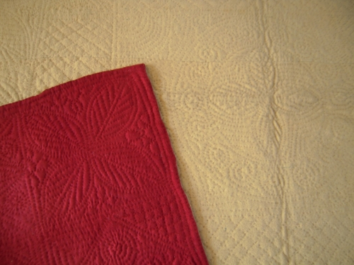 cream quilt with red corner turned over