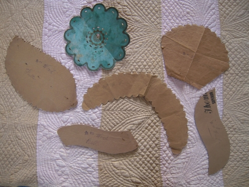 Card and paper templates laying on pink and gold strippy quilt