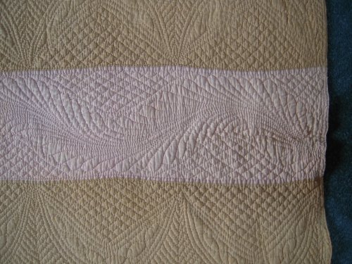 detail pf pink and gold strippy quilt