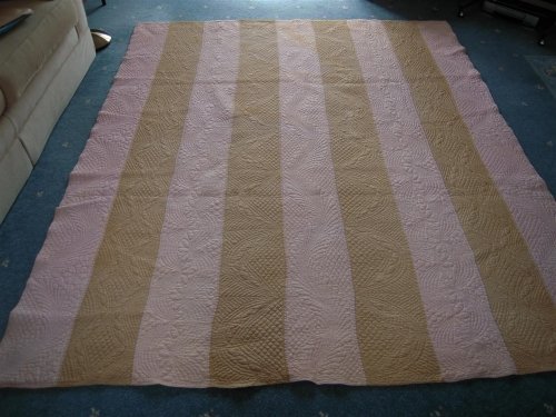 Gold and pink strippy quilt on floor