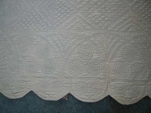 Scalloped edge of blue quilt