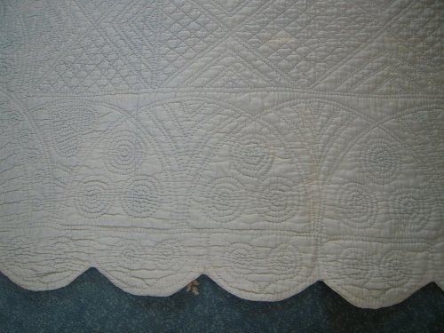Scalloped edge of blue quilt