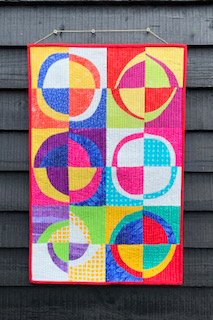 Modern Curves quilt, featuring bold colours and circular motifs