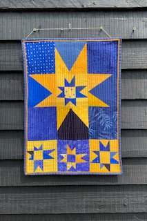 Wonky Stars Quilt, featuring a playful and imperfect starburst design in blue and yellow