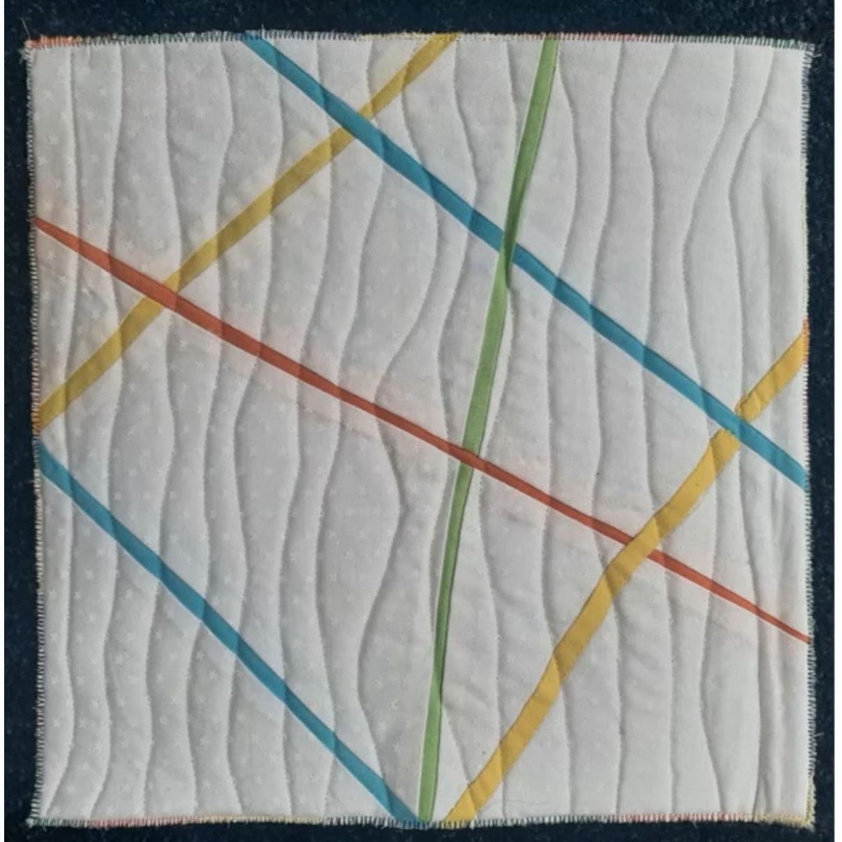 A square quilt with a white background. The quilt features colorful, diagonal lines in red, yellow, green, and blue. The background is quilted with a wavy pattern.
